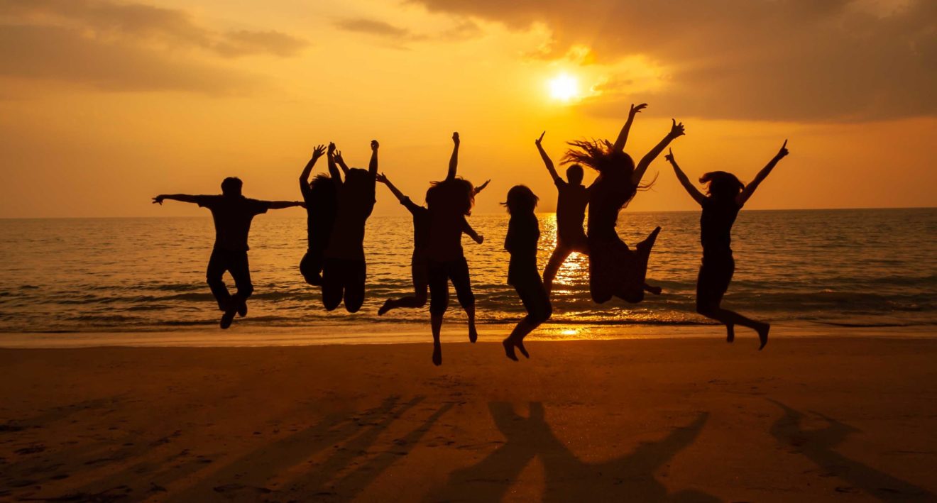 Silhouette photo of the team celebration on the beach at sunset
